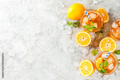 Cold summer drink. iced tea with lemon and mint, on grey stone background.  Copy space top view