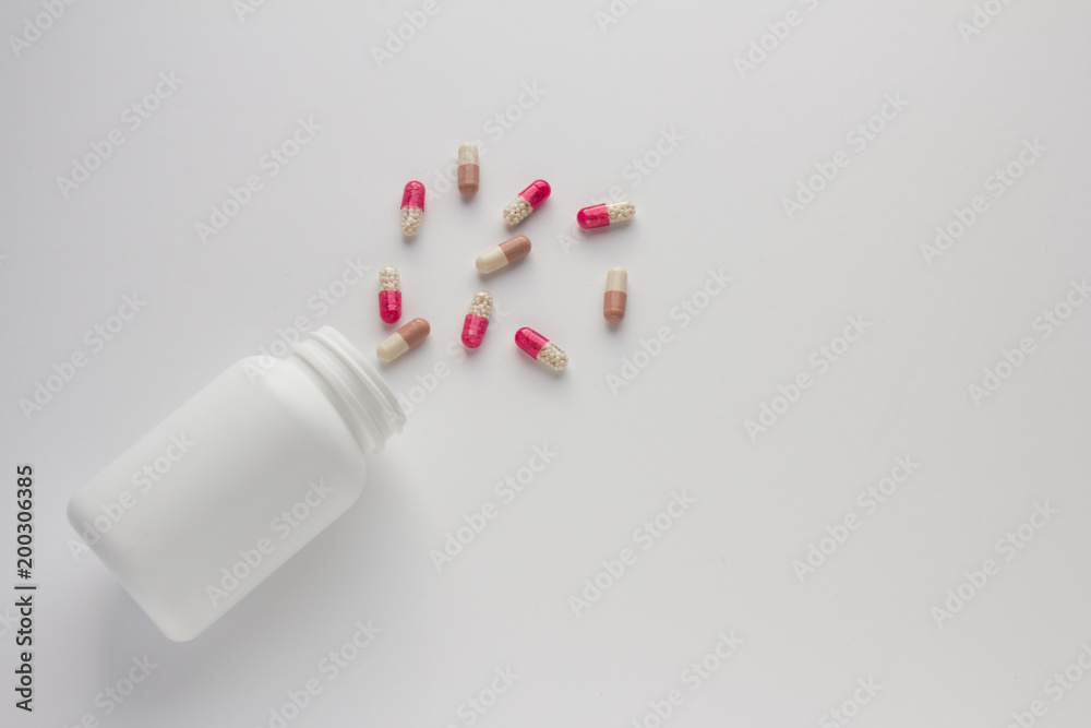 Assorted pharmaceutical medicine pills, tablets and capsules and bottle on white background. Copy space for text Assorted pharmaceutical medicine pills, tablets and capsules and bottle on white background. Copy space for text