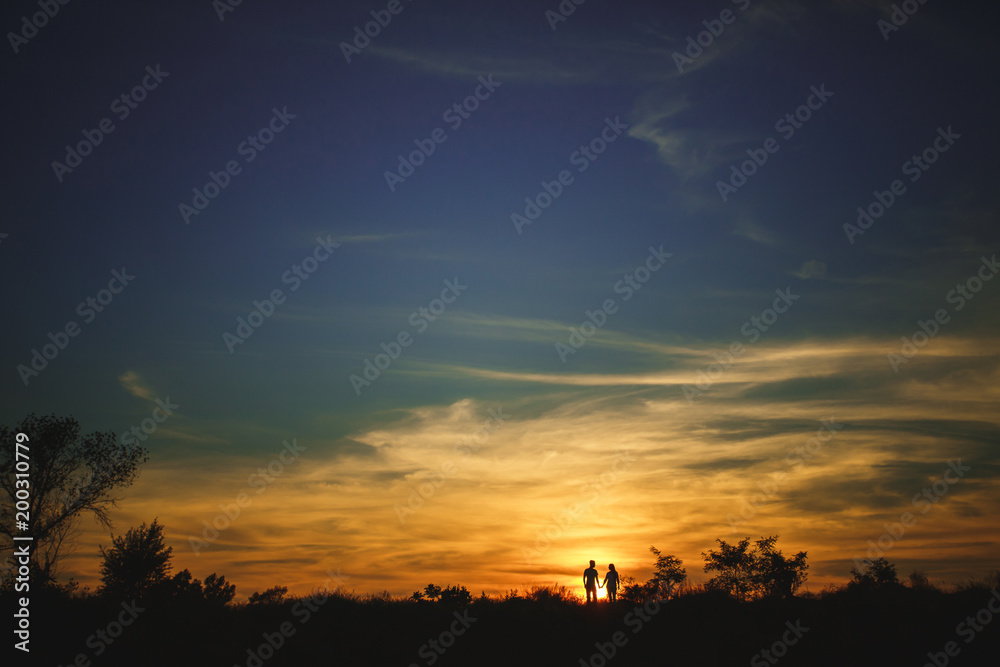 Silhouette couple in love enjoy good time together during sunset.