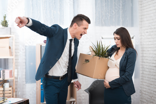 Young angry chief screams and fired upset pregnant girl with stuff box in office. photo