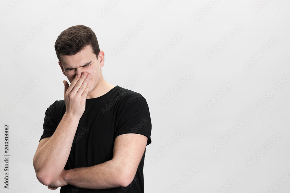 Closeup portrait, young man, disgust on his face, pinches his nose looks away, something stinks, very bad smell, situation, isolated white background. Negative emotion facial expression feeling Closeup portrait, young man, disgust on his face, pinches his nose looks away, something stinks, very bad smell, situation, isolated white background. Negative emotion facial expression feeling