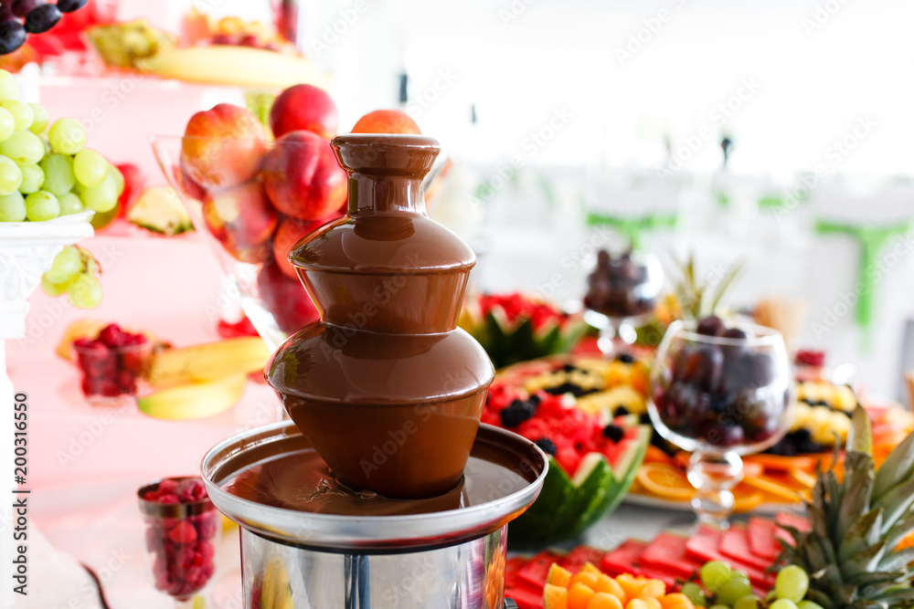 Chocolate Fountain And Fruits For Dessert At Wedding Table