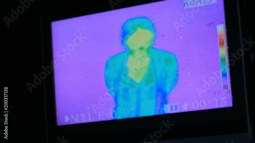 Thermographic camera view of woman. Blue, green, yellow colors show different temperatures photo