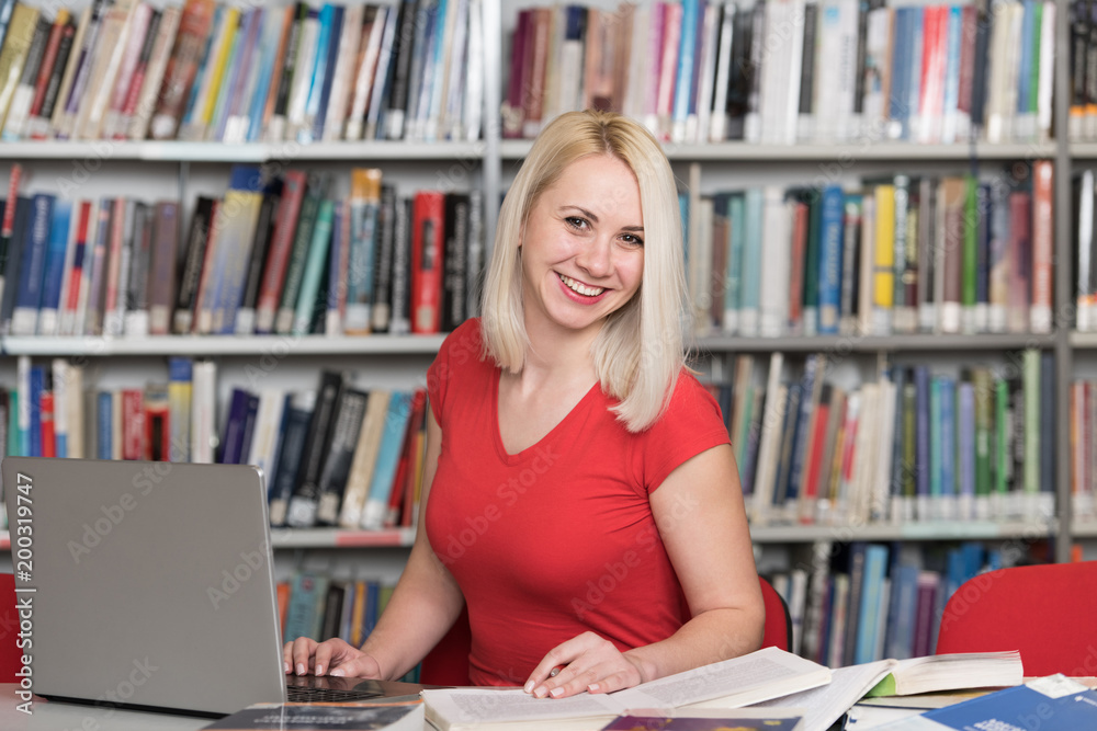 Happy Blonde Woman Working in the Library Happy Blonde Woman Working in the Library