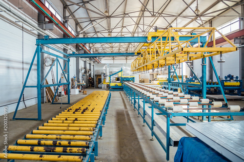 Insulation sandwich panel production line. Machine tools, roller conveyor in workshop