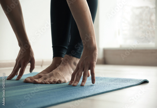 Young woman practicing yoga indoors, closeup