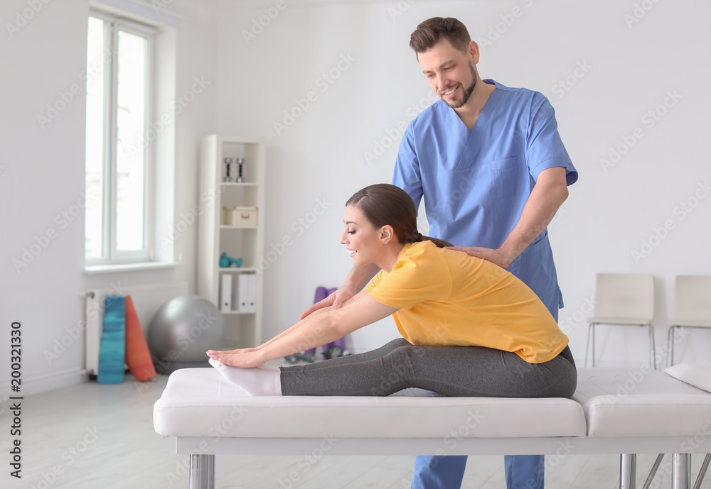 Physiotherapist working with female patient in clinic