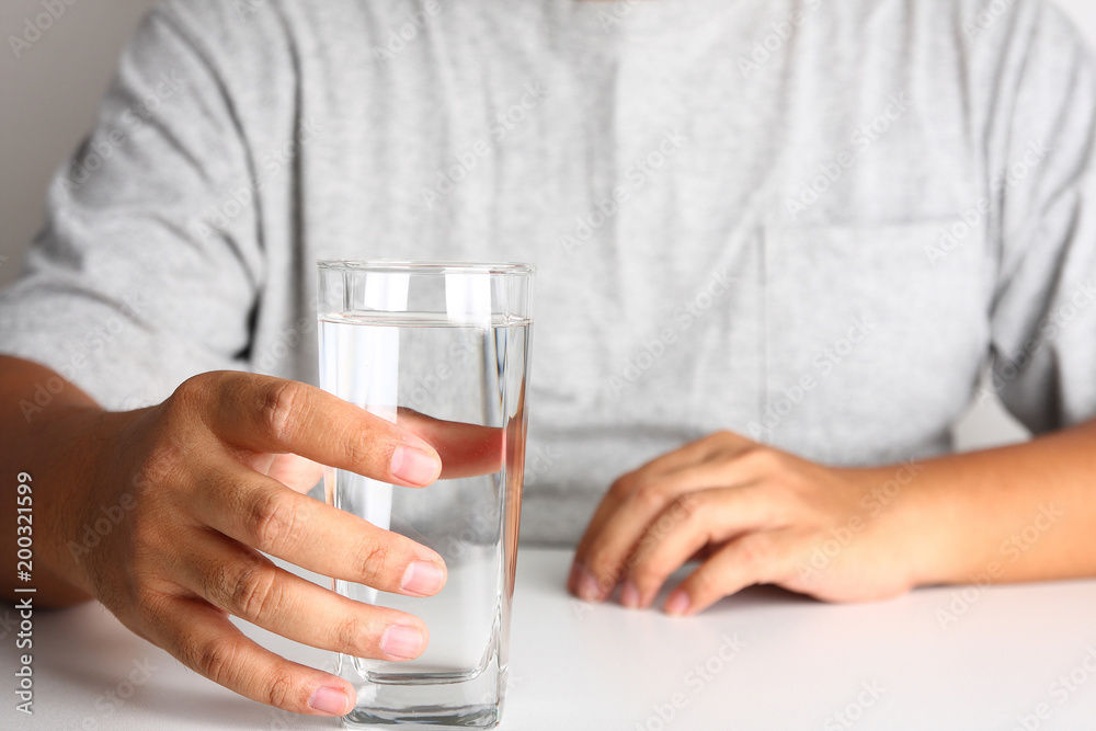 Men's gray coat sit, catch a glass of drinking water. Clean water and healthy. Men's gray coat sit, catch a glass of drinking water. Clean water and healthy.