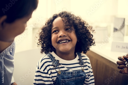Young cheerful black kid with family © Rawpixel.com