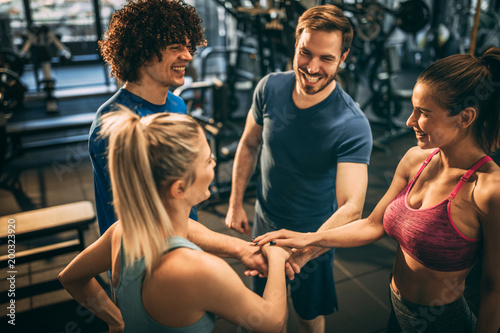 Group of young people in the gym. Having fun. Making a deal for best workout.