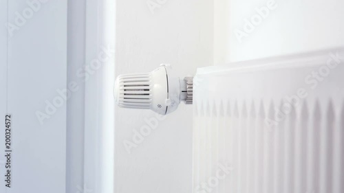 House heating - Hand adjusts the heating thermostat