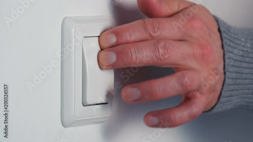 Hand turning on a light switch