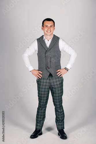 stylish man in checkered suit on a gray background
