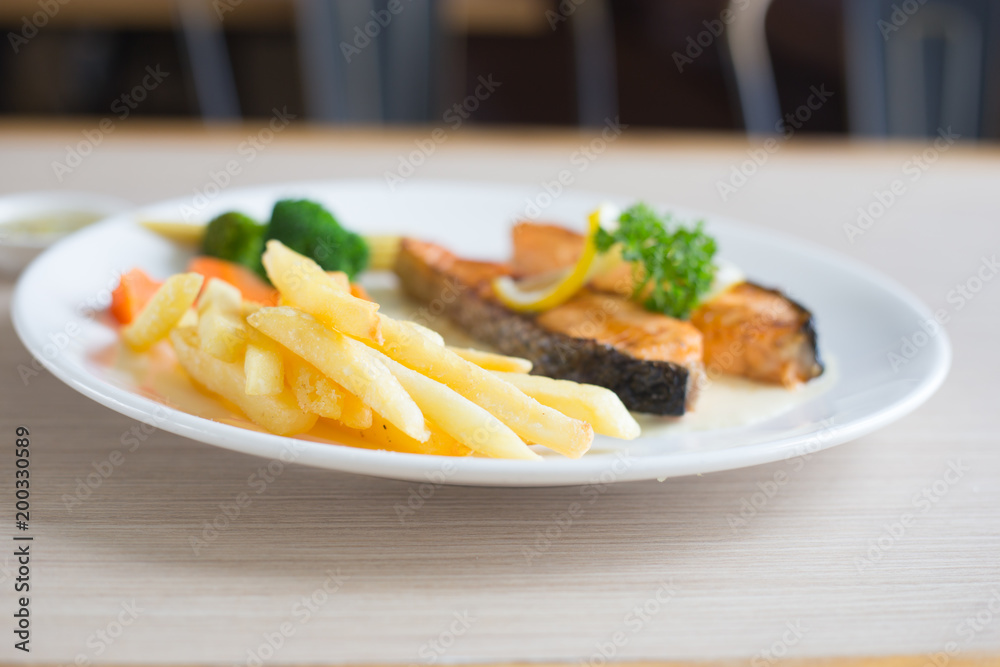 Salmon slice steak with yellow lemon decorated and vegetable, Fish &  chip
