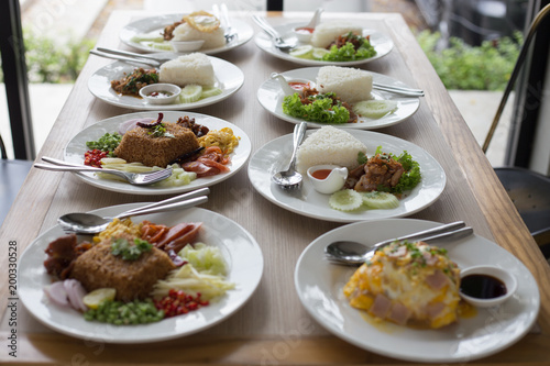 Many Thai food on white plates ready for eating