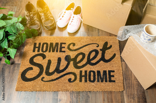 Home Sweet Home Welcome Mat, Moving Boxes, Women and Male Shoes and Plant on Hard Wood Floors