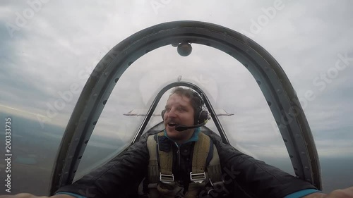 Smiling pilot sitting in the cockpit of a light aerobatic aircraft, emotions from the flight, aerobatics