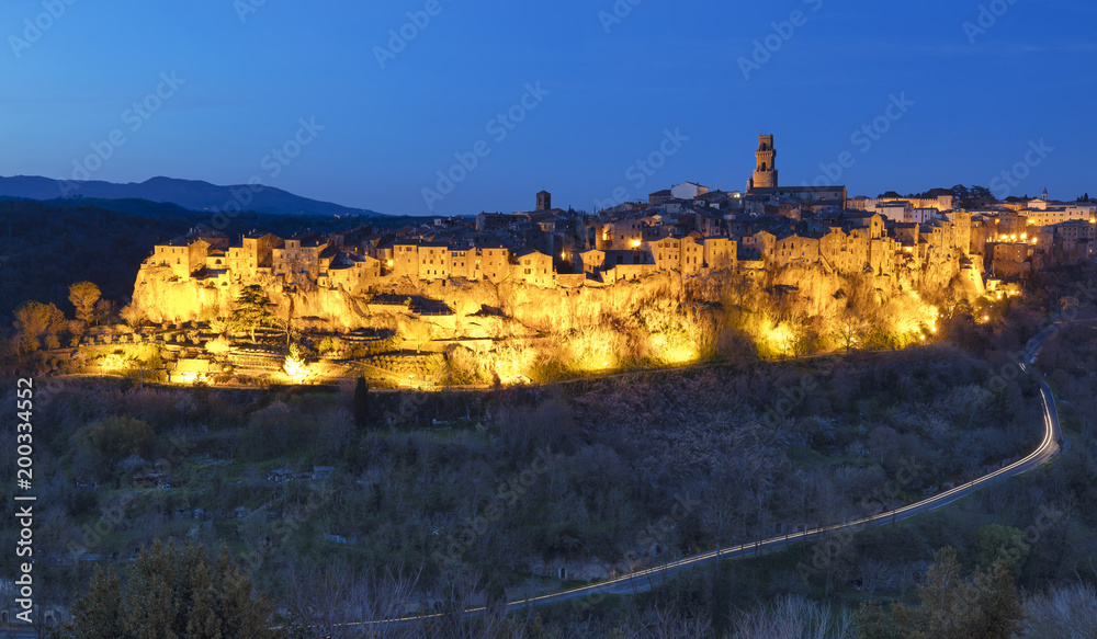 Golden light of old city in twilight time with car trails in Italy