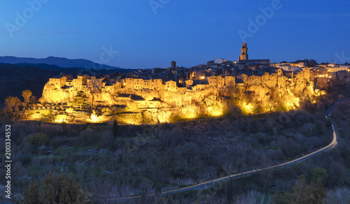 Golden light of old city in twilight time with car trails in Italy
