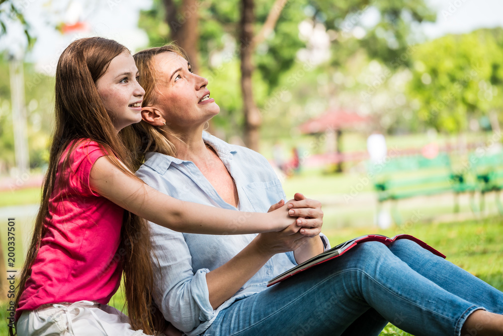 Mother and daughter relaxing in a park. Family and lifestyle concept Mother and daughter relaxing in a park. Family and lifestyle concept