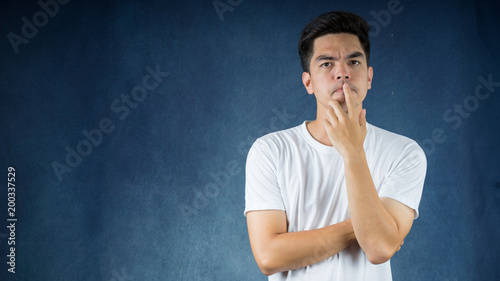 Portrait handsome young asian man wearing a white thinking and stress isolated on dark background.Asia man people. business concept.Copy space.