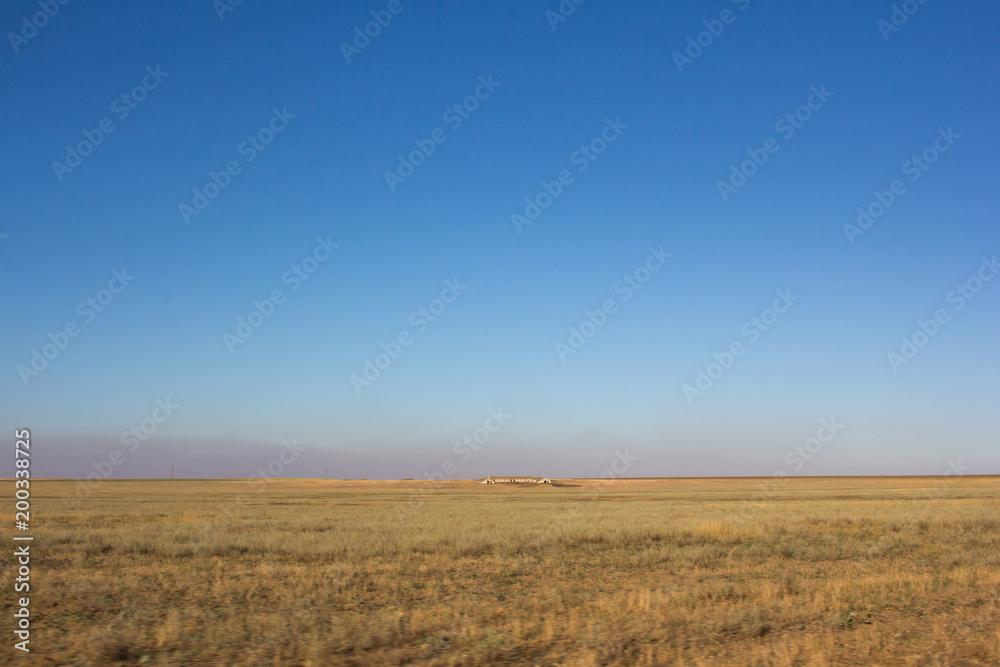 Desert dry steppe in summer and the structure in the middle of the field.
