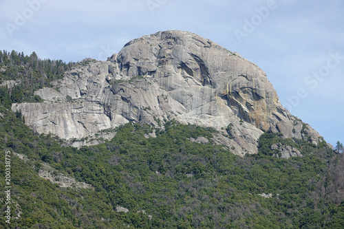 Moro Rock, a dome-shaped, granite monolith, is shown from a distant view on a spring day. The massive rock is located in the center of California's Sequoia National Park and is a popular hiking spot.