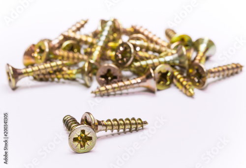 Tableau sur toile Bunch of yellow zinc coated philips flat head cross screws - fasteners on a whit