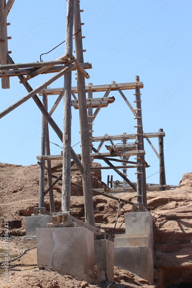 Fototapeta premium Wood pylons of cable car pods took sun dried salt out of a volcano crater historical engineered salt pans 150 yrs ago