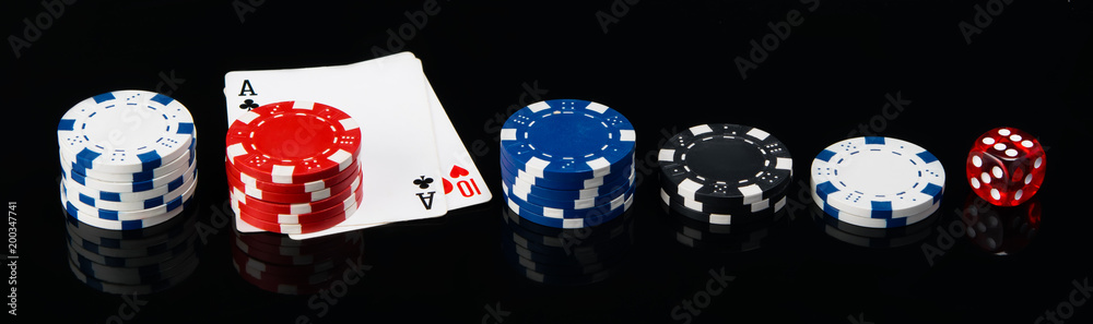 Obraz premium two cards and, laid out in a row, poker chips and a cube, on a black background
