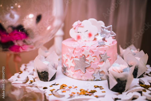 pink cake with stars and a unicorn at a birthday party for a child for a close-up