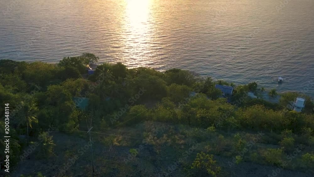 Aerial drone shot flying forwards and tilting up slowly to reveal a bright beautiful sunrise reflecting on the Bohol Sea in the Philippines Aerial drone shot flying forwards and tilting up slowly to reveal a bright beautiful sunrise reflecting on the Bohol Sea in the Philippines