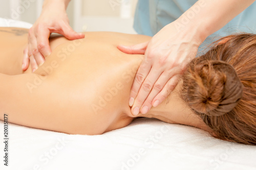 Masseur doing massage on woman body in the spa salon