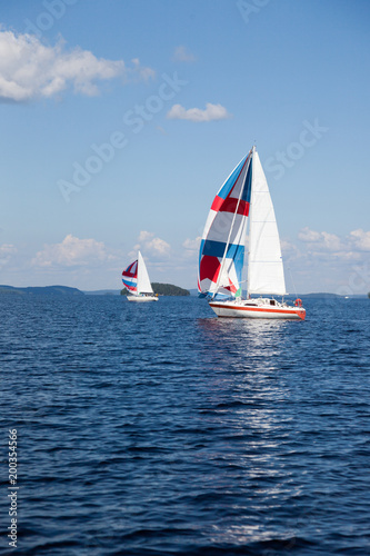 Two colorful sail on horizon on Lake Paijanne in Finland