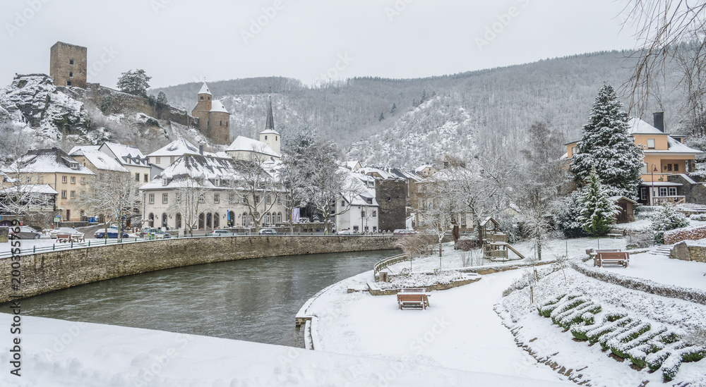 Fototapeta premium Snow covered Esch sur Sure town with lovely background of snow capped hills