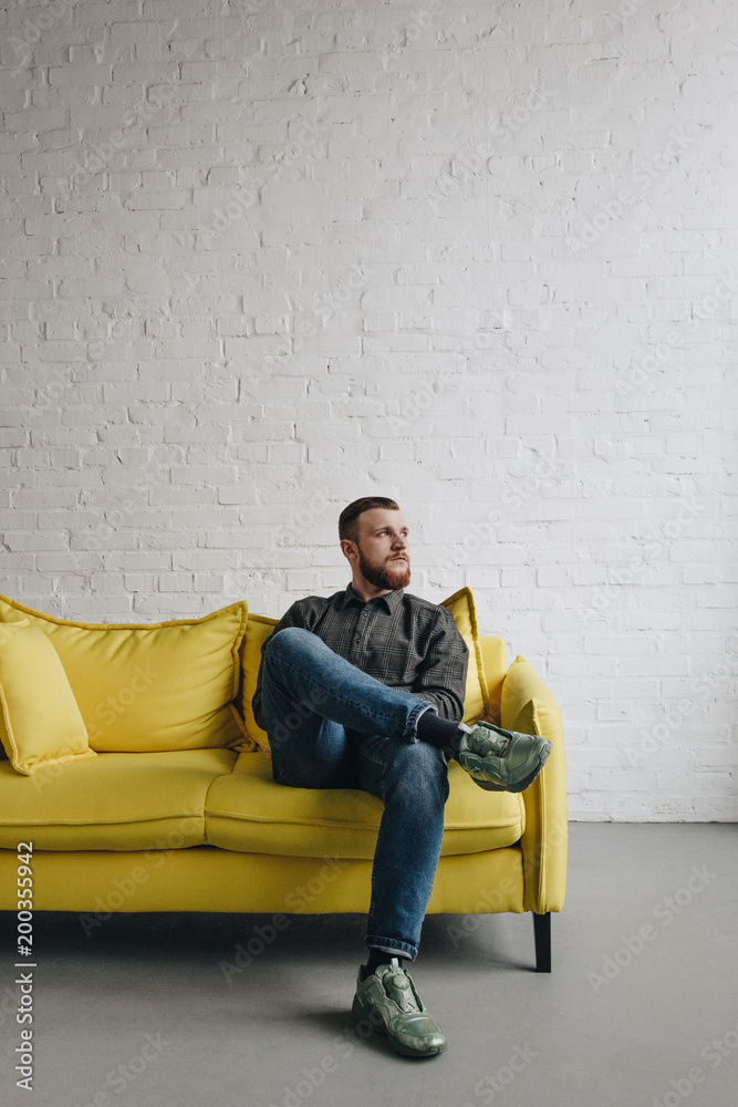 Caucasian man on yellow couch