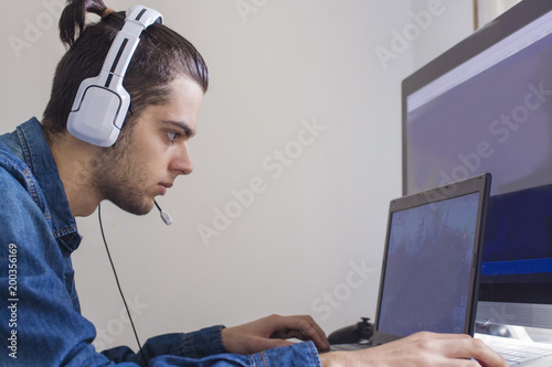 young with headphones and computer