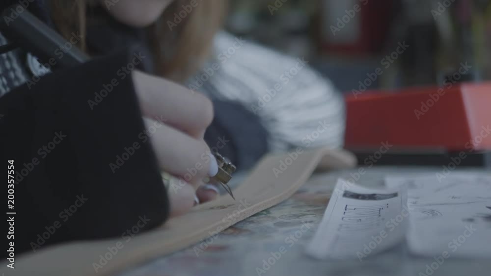 Woman uses a device for burning on natural leather. Creating and decorating of handmade wallet or bag. Close up view of artists working hands. 4k Woman uses a device for burning on natural leather. Creating and decorating of handmade wallet or bag. Close up view of artists working hands. 4k