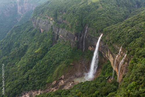 Nohkalikai waterfall surrounded by high cliffs and woodland and thick vegetation near Cherrapunji, Meghalaya, India.
