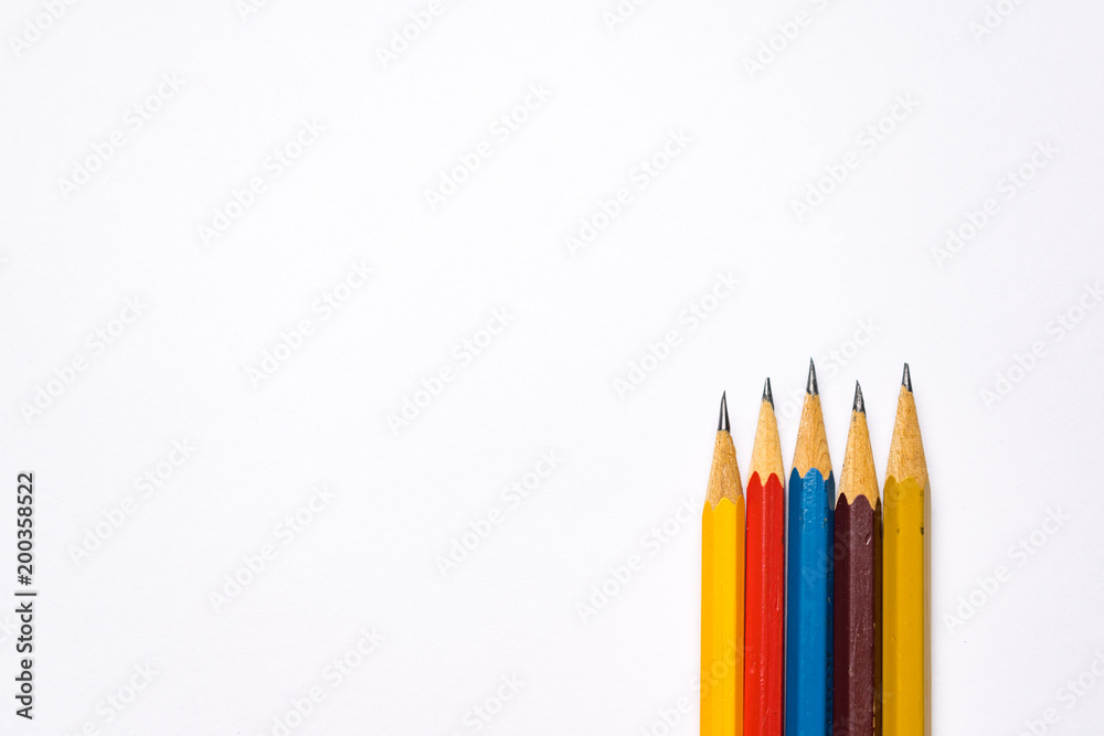 Bright colorful pencils next to a blank sheet of paper. School supplies stationery on a wooden texture table. Trendy minimalism. Concept back to school. Top view Bright colorful pencils next to a blank sheet of paper. School supplies stationery on a wooden texture table. Trendy minimalism. Concept back to school. Top view