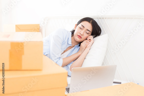 Young Asian Woman sleep while Working at home, Young Owner Woman Start up for Business Online. People with online shopping SME entrepreneur or freelance working concept. © Bavorndej