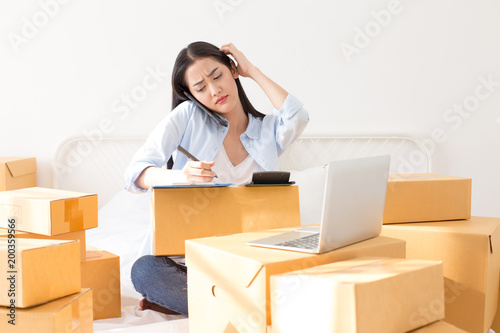 Young Asian Woman Working at home, Young Owner Woman annoyed customer and working with boring emotion. People with online shopping SME entrepreneur or freelance working concept.