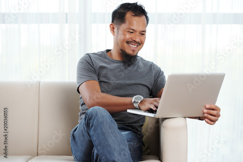 Photos Filipino cheerful man with laptop