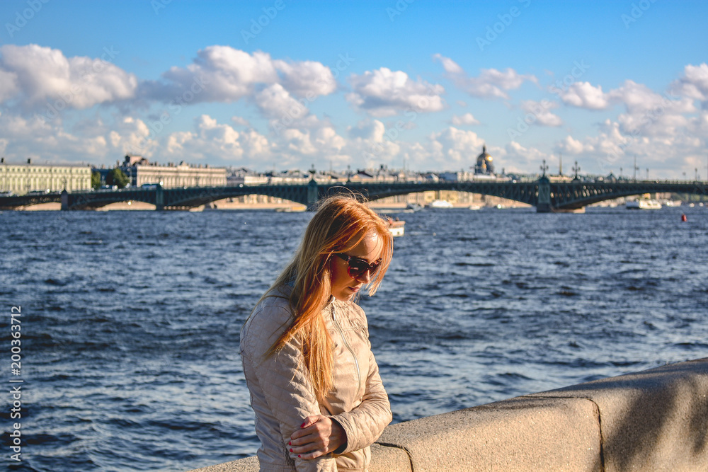 Girl strolls along the Neva embankment, St. Petersburg