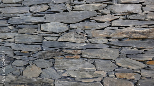 Wand aus sorgfältig gestapelten Natursteinstücken.
Sehr dekorativ für Haus oder Garten. 
Hintergrund. Detail. Textur. Fotografie. Nahaufnahme
 photo