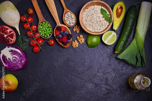 Selection of healthy food. Food background: quinoa, pomegranate, lime, green peas, berries, avocado, nuts and olive oil. Slate banner background. overhead, horizontal