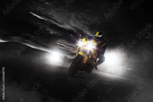 Supersport motorcycle driver at night with smoke around.