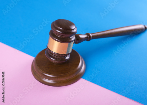Judge gavel or auction on pink and blue background. Justice and auction.