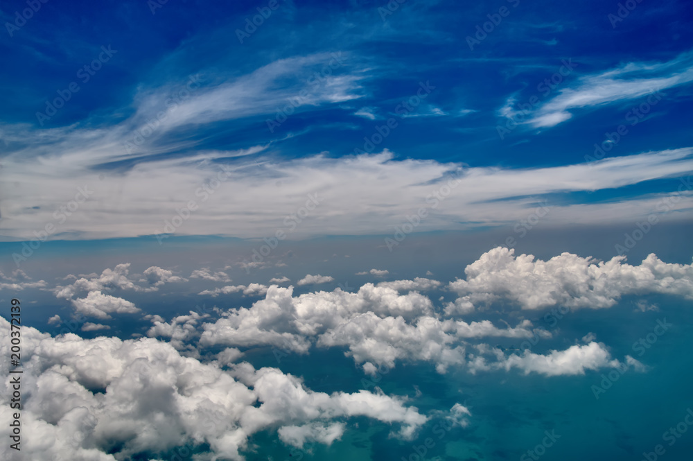 Beautiful blue sky and white clouds background. Sky atmosphere panorama. Heavenly bright daylights. Outdoor planet. Photo from the aircraft window. Beautiful blue sky and white clouds background. Sky atmosphere panorama. Heavenly bright daylights. Outdoor planet. Photo from the aircraft window.