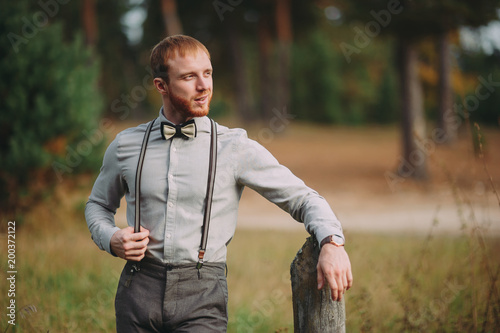 Fototapeta Naklejka Na Ścianę i Meble -  Hipster. Stylish groom with beard posing outdoors